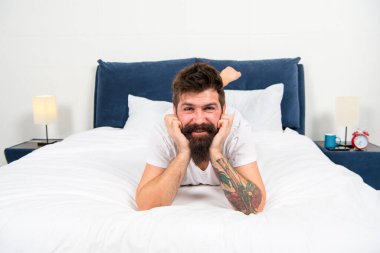 Evde kal. Mutlu hipster kendini evinde güvende hissediyor. Sakallı adam yatakta rahatla. Dinlen ve rahatla. Dinlenme ve dinlenme odası. Ev kıyafetleri. Moda ve tarz. Kendini izole et ve karantina altına al. Ev en iyisi.
