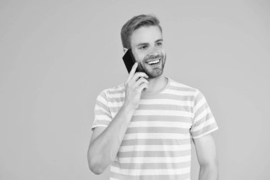 İletişim kurmanın önemini. Cep telefonunun sarı arka planında mutlu adam konuşması. Sözlü iletişim. Mobil iletişim. Telefon iletişimi. İletişim teknolojisi. Modern hayat