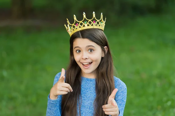 Accesorio de baile para ti. Chica del baile señalando con los dedos hierba verde. Feliz niño lleva corona de graduación. Fiesta de graduación. Concurso de belleza. Gran jefe. Orgullo y gloria. Moda y estilo de lujo. Vacaciones de verano — Foto de Stock