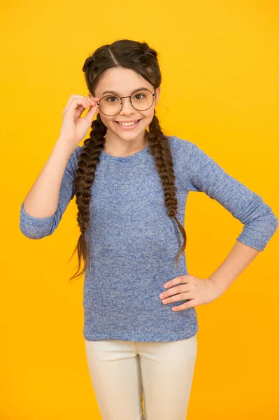 Déjeme ver. Leyendo mejor con anteojos. Gafas para la salud de los ojos. Una chica inteligente. Las alumnas de la escuela usan anteojos de fondo amarillo. Adorable nerd. Concepto de colegiala. Chica inteligente mala vista —  Fotos de Stock