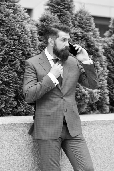 Llamada de negocios. Un tipo con estilo usa esmoquin. Mantente conectado. Empresario hablar de teléfono móvil. Hombre barbudo guapo con teléfono celular al aire libre. Estilo de vida móvil. Comunicación empresarial. Tecnología móvil — Foto de Stock