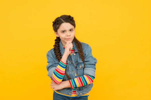 Piccolo ma intelligente. Ragazzina con sguardo premuroso. Piccolo bambino indossare lungo intrecciato acconciatura. Adorabile bambino piccolo in stile casual. Bellezza e moda. Salone da parrucchiere. Prodotti per bambini — Foto Stock