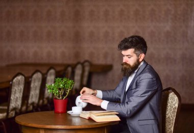 Son sınıf öğrencisi evde çayla kitap okuyor.