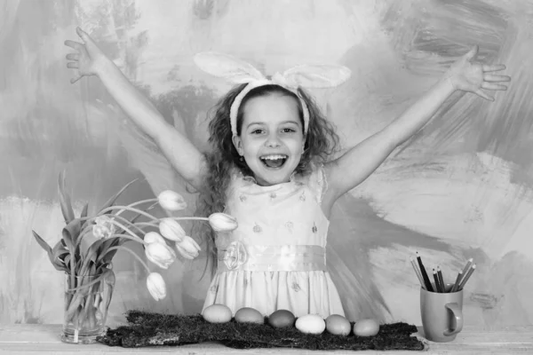 Glad påsk flicka i kanin öron med pennor, ägg, blommor — Stockfoto