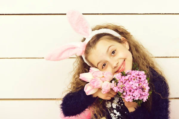 Glad flicka i påsk kanin öron med rosa tulpan blomma — Stockfoto