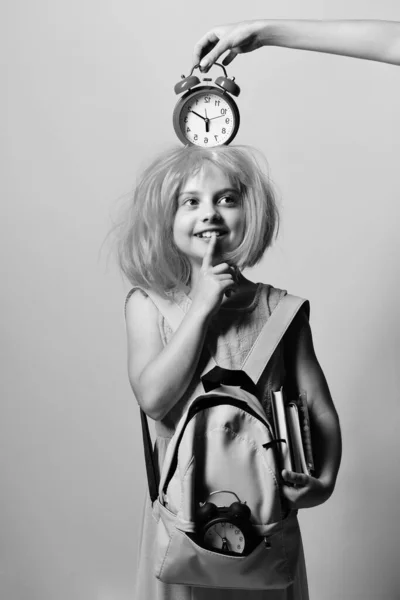 Pupil in school uniform with wig and alarm on head — Stock Photo, Image