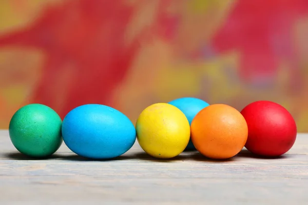 Huevos de Pascua pintados en línea o fila sobre fondo colorido — Foto de Stock