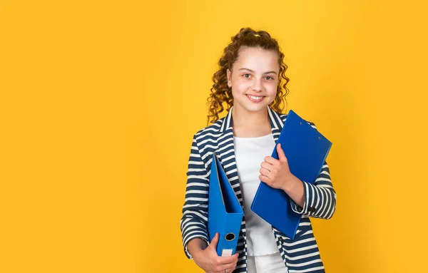 Menina pequena com pasta de escritório. Uma mulher de negócios. infância feliz. miúdo com cabelo encaracolado usar casaco. trabalhar com documentos. estudante tem papelada lição de casa. voltar para a escola — Fotografia de Stock