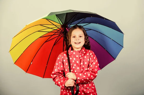 행복 한 소녀는 화려 한 무지개 우산을 들고 있다. 적절 한 옷을 입은 날씨. 좋은 하루되 세요. 우산 아래를 걷는게좋을 거야. 비가온 후에는 언제나 무지개가 있다. 비개념을 즐기 세요. 가을 시즌 — 스톡 사진
