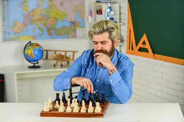 Chess is gymnasium of mind. Chess lesson. Strategy concept. School teacher. Board game. Smart hipster man playing chess. Intellectual hobby. Figures on wooden chess board. Thinking about next step