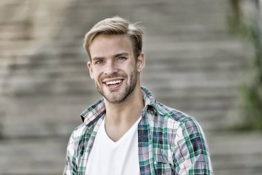 Yakışıklı ve mutlu. Yakışıklı adam dışarıda gülümsüyor. Yakışıklı bir genç adam görünüşü. Erkek bakımı. Kuaför salonu. Berber dükkanı. Moda modası. Sıradan bir tarz. Her yaşta yakışıklı, klasik filtre.