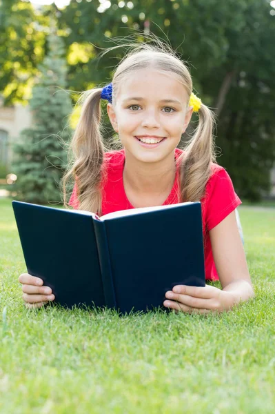 Letní čtenářský klub. Šťastná holka čte knihu o zelené trávě. Letní čtenář. Letní prázdniny. Školní prázdniny. Rekreace a volný čas. Přečtěte si více letos v létě — Stock fotografie