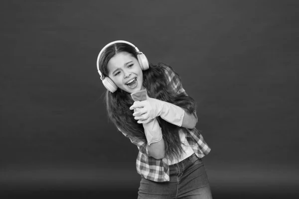Πάρτι καθαρισμού. Κορίτσι φορούν ακουστικά και προστατευτικά γάντια για τον καθαρισμό. Ακούγοντας μουσική και καθαρίζοντας. Διασκεδάζω. Κάνε το σπίτι πιο χαρούμενο. Αβλαβή καθαριστικά με απλά συστατικά — Φωτογραφία Αρχείου