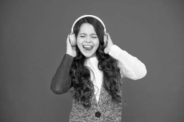 A vida é música, canta-a. Criança feliz cantar música fundo vermelho. A menina ouve música nos auscultadores. Vida moderna. Nova tecnologia. Música e música. Diversão e entretenimento — Fotografia de Stock