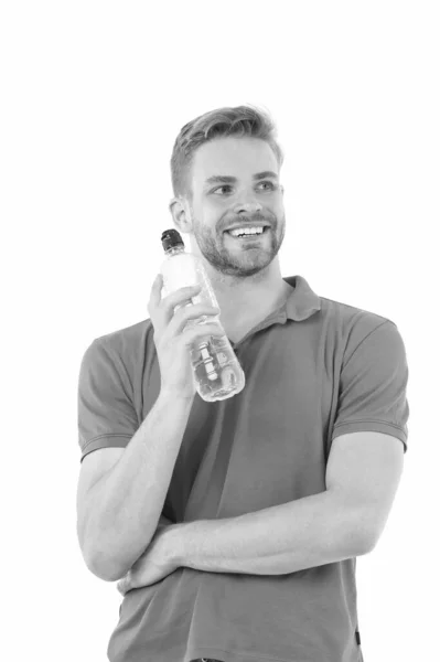 Saúde e hidratação. Um tipo feliz mantém a garrafa de água isolada no branco. Um homem sedento usa camisa de pólo. Sede e perda de água. Balanço hídrico no corpo humano. Ingestão e produção saudáveis. Beba mais água — Fotografia de Stock