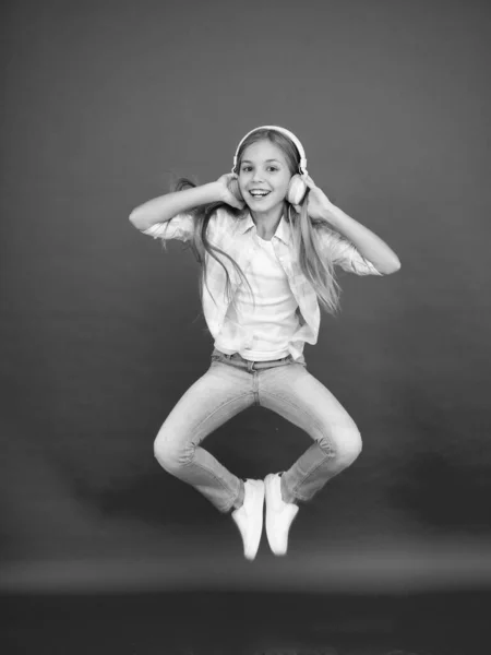 ヒップスター・キッドが動き続ける。精力的な子供踊り。幸せな子供時代。音楽にインスパイアされました。春休み時間だ。勝利を祝う少女。イヤホンの女の子。動きが楽しい。小さな岩の星 — ストック写真