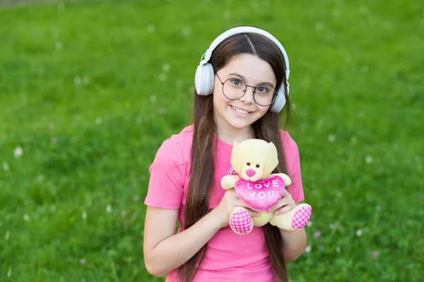 Connexion d'amour. Joyeux enfant tenir jouet ours en peluche. Petite fille jouer avec jouet à l'extérieur. Magasin de jouets. Boutique de cadeaux. Présence de valentines. Jeu d'enfance. Amusant. Temps de jeu. Adorable jouet à tomber amoureux — Photo