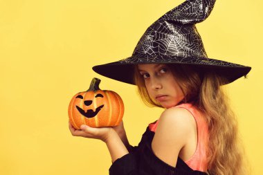 Cadı kostümü giymiş çocuk ve Jack O Lantern.