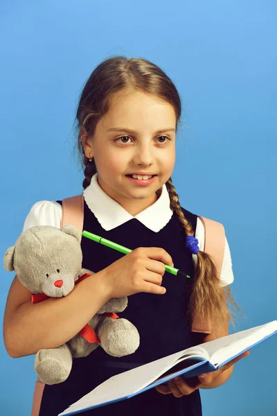 Školní dívka s úsměvem tvář izolované na modrém pozadí — Stock fotografie