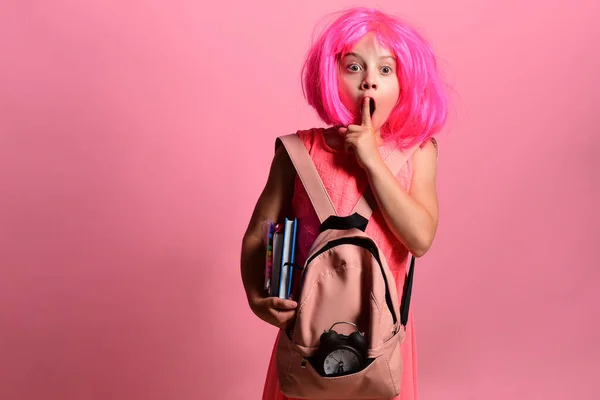 Chica de la escuela con la cara sorprendida y el gesto de silencio lleva mochila — Foto de Stock