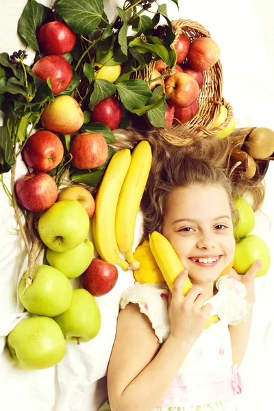 Niedliche Baby-Mädchen legen mit bunten Früchten im Korb — Stockfoto