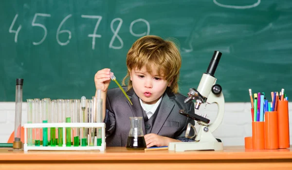 Teknik och vetenskap koncept. Pojke nära mikroskop och provrör i klassrummet. Grabben studerar biologi och kemi i skolan. Skolutbildning. Utforska biologiska molekyler. Knäppskalle — Stockfoto