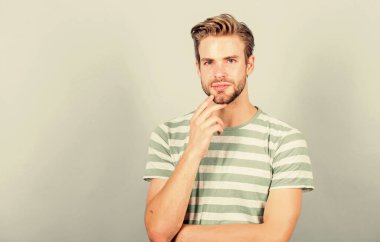 Gündelik stilde seksi maço. Mükemmel kaslı adam görünüşü. Yaz modası. Tıraşsız öğrenci. Erkek modası ve güzellik. Moda tişörtlü düşünen bir adam. Erkek manken. Saç ve sakal bakımı
