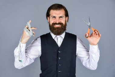 Erkek kıyafetlerine terzilik eden mutlu bir adam. Vahşi adam moda tasarımcısı. Erkekler için tasarım yapan bir adam. Başarılı sartor çalışmaya hazır. Resmi ve ofis tarzı. Mezura ve makaslı terzi.