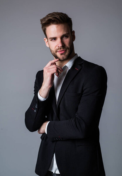 his perfect style. Young handsome man. Young manager in his office. portrait of a businessman on grey background. confident businessman portrait. Portrait of a handsome CEO. Businessman in suit