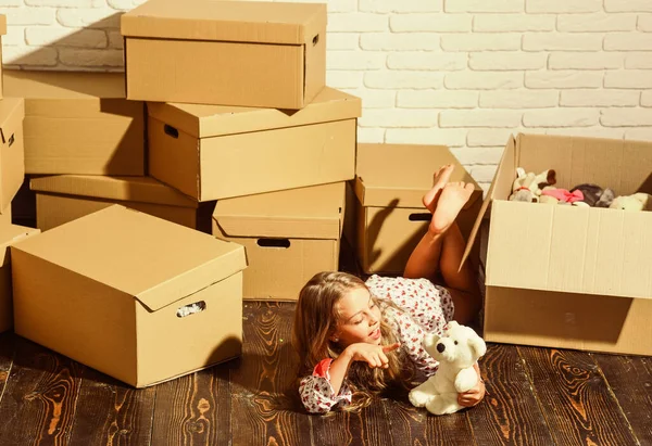 Live Where You Work and Play. purchase of new habitation. happy little girl with toy. Cardboard boxes - moving to new house. playing into new home. new apartment. happy child cardboard box — Stock Photo, Image