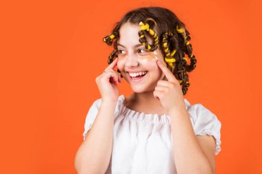 Çocuklar için saç stili yapmak için kolay ipuçları. Kuaför aletleri ve saç aksesuarları. Yüzü yamalı çocuk. Saç bigudileriyle poz ver. Kuaförde oynayan, saç bigudili mutlu kız. Boşluğu kopyala