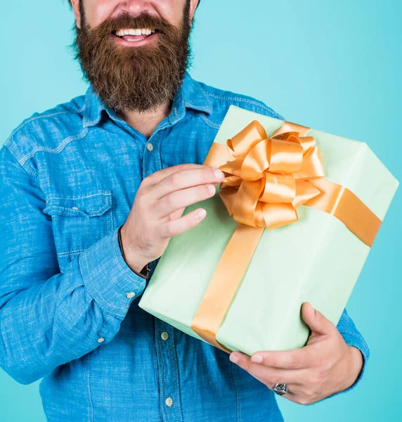 Бородатий чоловік подарував святкові прикраси. бізнесмен тримає велику подарункову коробку. подарунок колезі на роботі. здивований чоловік розпаковується. доставка посилок. людські емоції та вираз обличчя — стокове фото