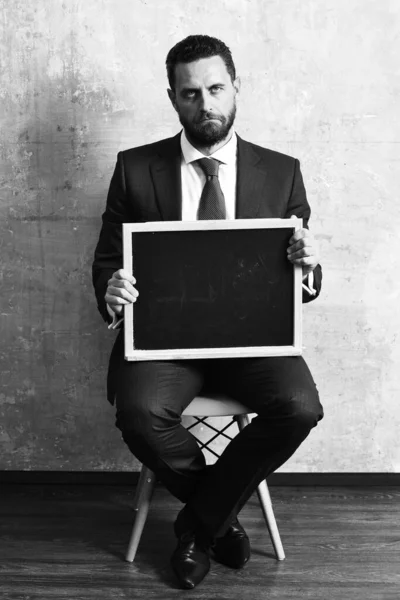 Homem de negócios ou triste segurando um quadro negro — Fotografia de Stock