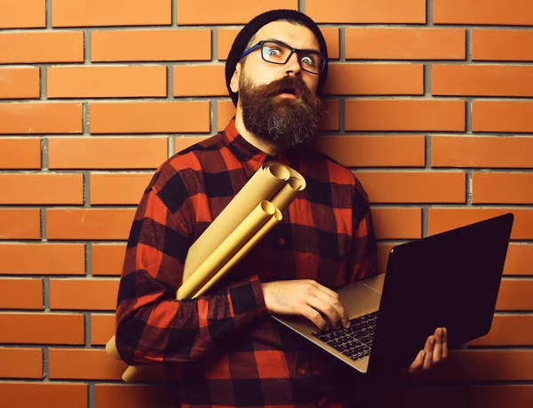 Skäggig brutal kaukasisk hipster med bärbar dator och hushållspapper — Stockfoto