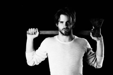 Kaba sakallı, şık saçlı bir adam yaşlı baltayı tutuyor.