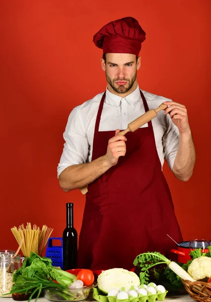 Homem em chapéu de cozinheiro e avental se prepara para cozinhar . — Fotografia de Stock