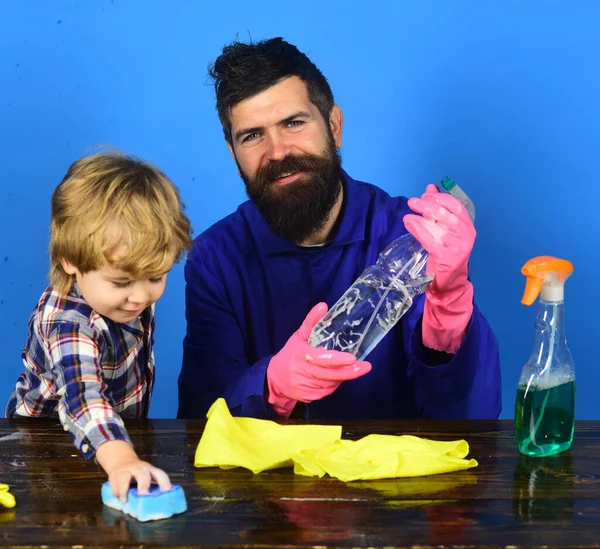 Guy with beard and mustache with rubber gloves holds spray