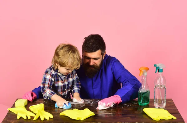 Hijo y padre cerca de aerosoles y guantes sobre fondo rosa . — Foto de Stock