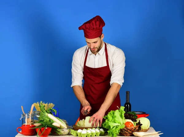 Mann in Kochuniform schneidet Kohl. Chef mit geschäftigem Gesicht — Stockfoto