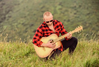 Dağın tepesinde gitarlı bir adam. Akustik müzik. Ruh için müzik. Müzik çalıyordu. Özgürlüğün sesi. Müzisyen yürüyüşçü dağlarda ilham bulur. Doğayla uyum içinde. Sakin ol ve gitar çal.