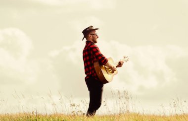 Güzel bir melodi çal. Gitarlı yakışıklı bir adam. Köy tarzı. Yaz tatili. Country müzik konsepti. Gitarist country şarkıcısı arka planda duruyor. Country müzisyeninden esinlendim. Yürüyüş şarkısı