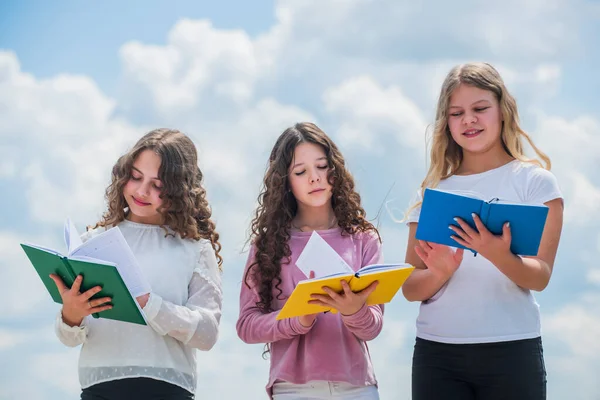 Conceito de educação e escola. Estudantes de escola aprendendo literatura. crianças lendo livros. três meninas escrevendo no caderno. de volta à escola. escrever memórias em diário — Fotografia de Stock