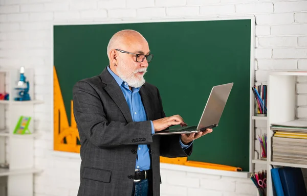 Wideokonferencje podtrzymują więzi między uczniami. Starszy nauczyciel używa laptopa. Odległe cele edukacyjne. Koncepcja edukacji szkolnej. Przydatna wiedza. Trendy edukacyjne. Usługa online — Zdjęcie stockowe