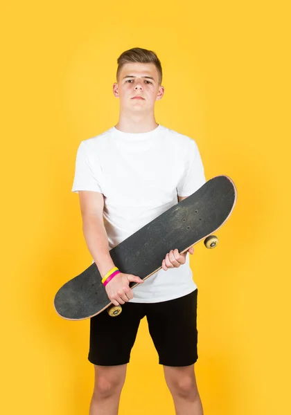 Hipster adolescente chico hold penny board. chico urbano con monopatín penny. El chico joven tiene pasatiempo a caballo. estilo ciudad. niño aprende a montar penny board. patinador adolescente de moda practicando. adolescente chico con monopatín — Foto de Stock