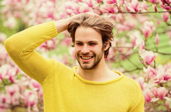 Spring season. Man flowers background defocused. Spring beauty. Botany and nature. Happy spring concept. Hipster enjoy blossom aroma. Springtime concept. Unshaven man sniff bloom of magnolia