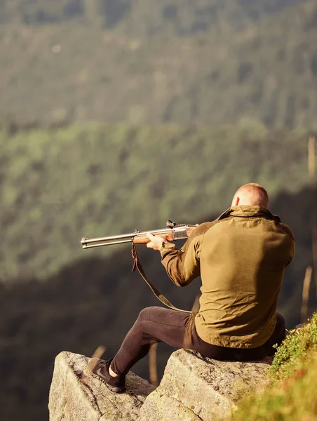 Hunter petrece timpul liber de vânătoare. Omul brutal gamekeeper natura peisaj fundal. Vânătoare în munţi. Conceptul de hobby masculin. Regulament de vânătoare. Concentrat pe ţintă. Hunter hold pușcă — Fotografie, imagine de stoc