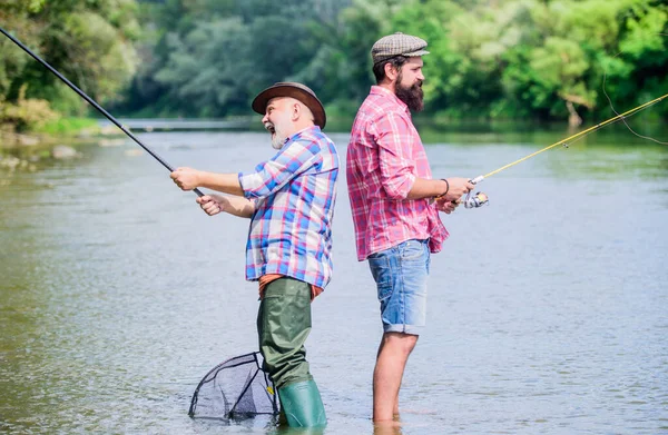 Father and son fishing. Fisherman fishing equipment. Fisherman grandpa and mature man friends. Fisherman family. Hobby sport activity. Summer weekend. Peaceful activity. Nice catch. Rod and tackle