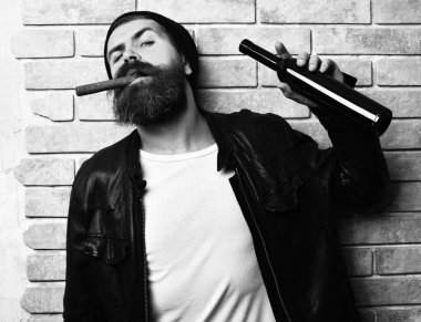 Sakallı, Kafkas hippisi elinde şişe, puro içiyor.