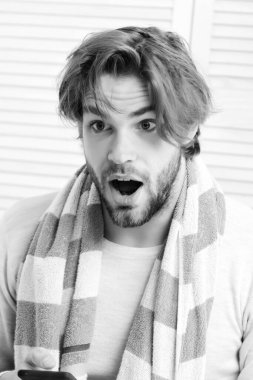 Beyaz perdelerde çizgili mavi beyaz havlusu olan adam.