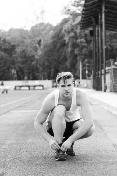 Deportista ata a sus entrenadores sentados y preparándose para correr — Foto de Stock